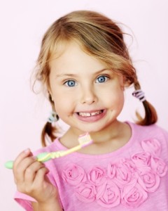 Child happily brushing her teeth